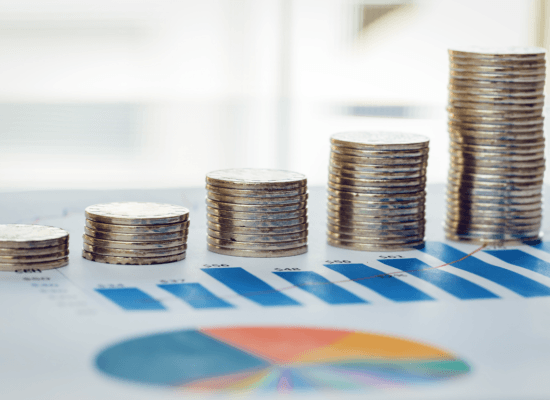 Stacks of coins on business charts symbolize financial growth, highlighting the economic impact and success of black business.